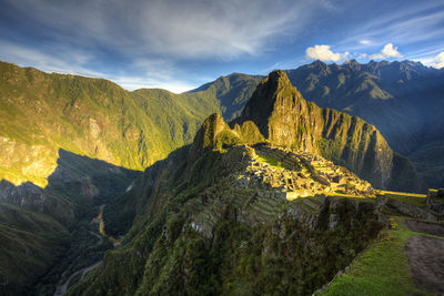 Scenic view of mountain range against cloudy sky