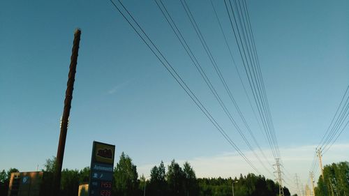 Low angle view of power lines against blue sky