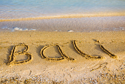 High angle view of bali text on beach