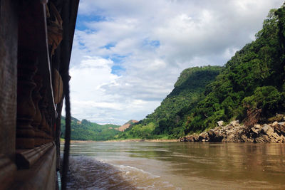 Scenic view of river by mountains against sky