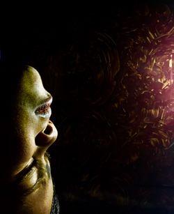 Close-up portrait of a young woman over black background