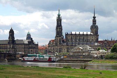 Buildings in city against cloudy sky