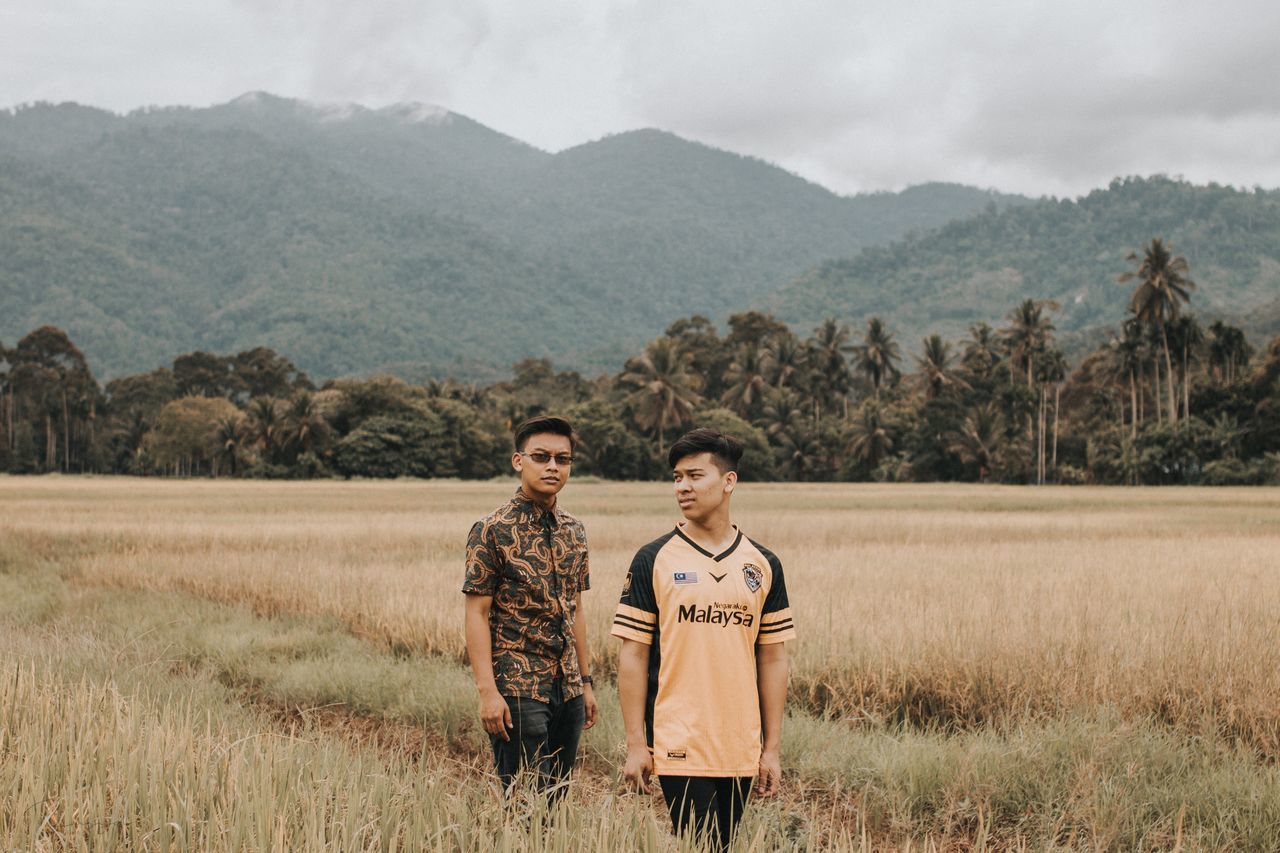 mountain, standing, two people, beauty in nature, plant, scenics - nature, land, nature, togetherness, field, adult, young adult, landscape, emotion, non-urban scene, real people, sky, men, mountain range, lifestyles, outdoors