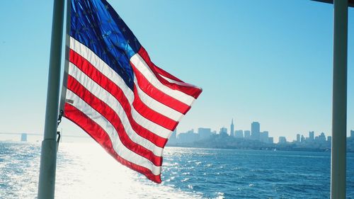 Close-up of flag in city against clear sky