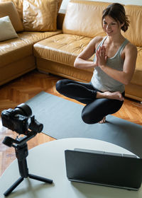 Woman sitting on sofa at home