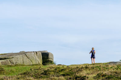 Rear view of woman standing on land against sky