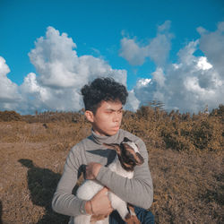 Young man on field against sky