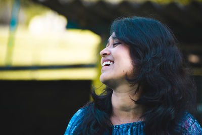 Close-up of cheerful young woman standing outdoors