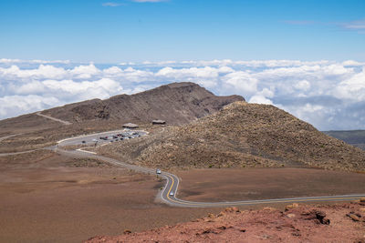 Scenic view of road by mountains against sky