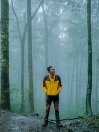 Full length portrait of man standing in forest