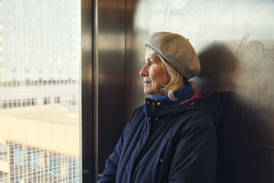 Senior woman looking through window