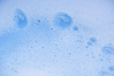 Full frame shot of water drops on blue background