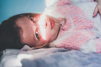 Portrait of woman lying on bed