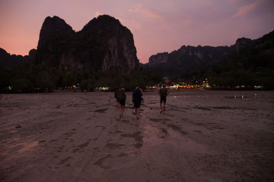 Tourists on mountain at sunset