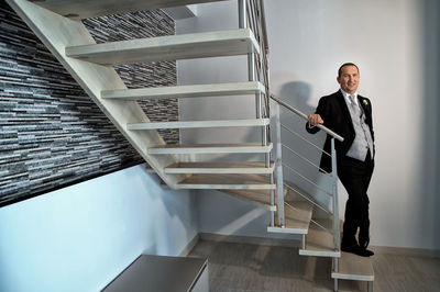 Full length portrait of businessman standing on steps