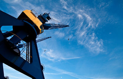 Low angle view of crane against blue sky