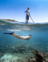 Young couple have a fun in ocean water, underwater view