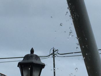 Low angle view of bird perching on water against sky