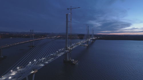 Suspension bridge over river against sky