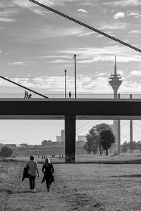 People walking on bridge against sky