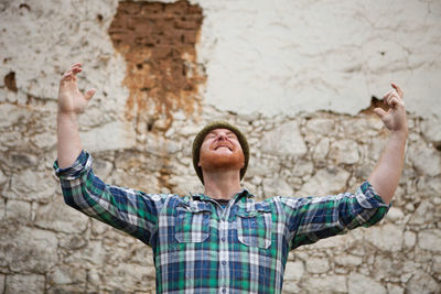 Portrait of man with arms raised