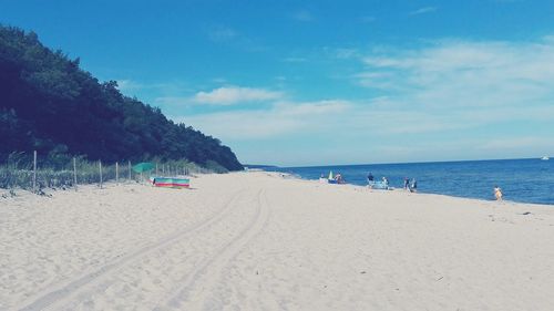 View of calm beach against blue sky