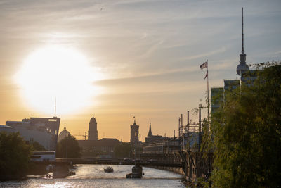 Bridge over river against buildings in city