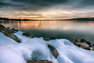 Fantastic snowy landscape on lake constance at sunset with stones