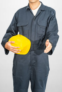 Midsection of man holding umbrella against white background