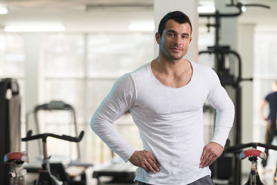 Muscular man wearing vest standing in gym