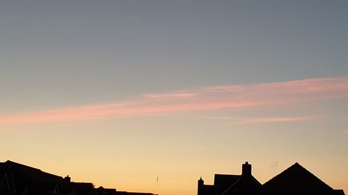 Low angle view of silhouette buildings against sky