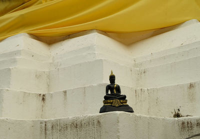 Low angle view of yellow lantern on building wall