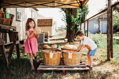 Young brother and sister shopping for fruit at local outdoor market