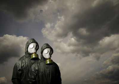 Rear view of man standing against cloudy sky