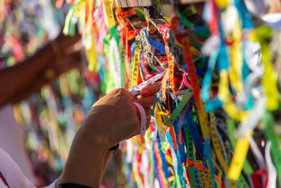 A catholic faithful is seen tying a souvenir ribbon on the railing of the senhor do bonfim church 