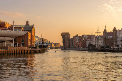 Buildings at waterfront during sunset