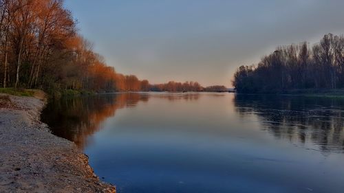 Scenic view of lake against sky at sunset