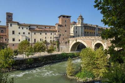 Arch bridge over river against clear sky