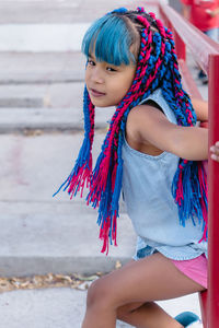 Low angle view of girl holding multi colored umbrella