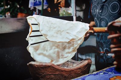 Midsection of man cooking flatbread at market stall