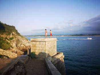 Rear view of man by sea against sky