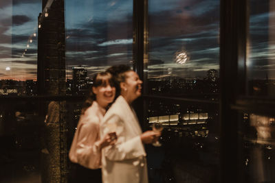 Woman standing by window in city