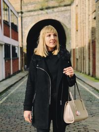 Portrait of beautiful woman standing against wall