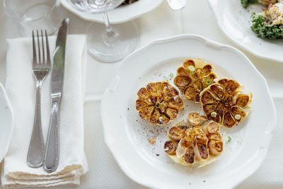 Roasted garlic dish in olive oil in luxury restaurant. white beautiful restaurant europe style.