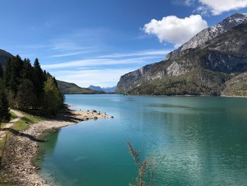 Scenic view of lake by mountains against sky