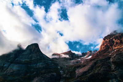 Low angle view of clouds over mountain against sky