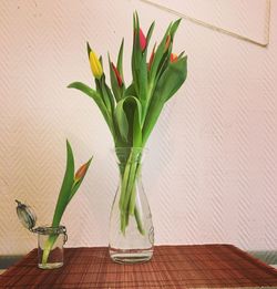 Tulip buds in vase on table at home