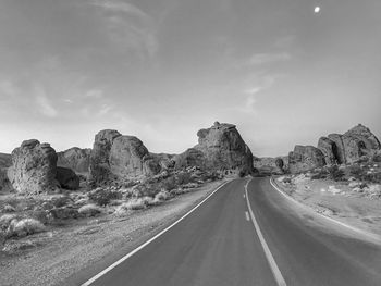 Road amidst rock formations against sky