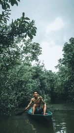 Young man in lake against sky