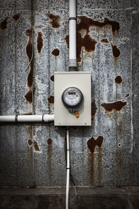 A minimalistic closeup of a brand new hydro meter mounted on a old abandoned industrial building.